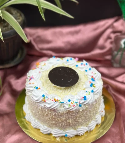 Slice of White Forest cake in Pokhara showing vanilla sponge, cherry compote, and white chocolate mousse