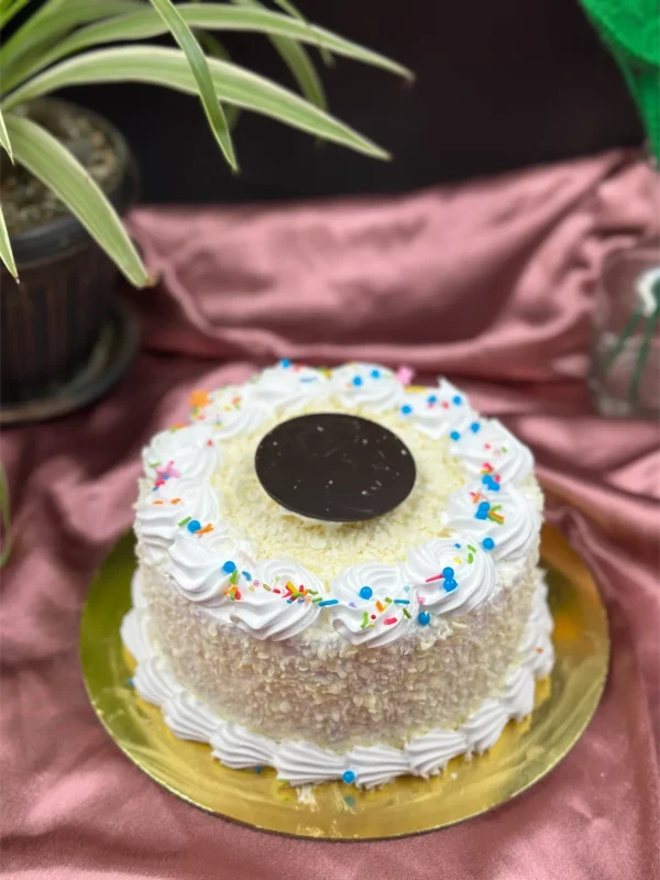 Slice of White Forest cake in Pokhara showing vanilla sponge, cherry compote, and white chocolate mousse