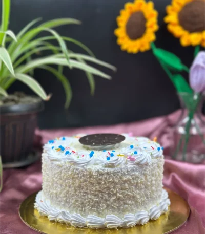 Whole White Forest cake decorated with white chocolate curls and sprinkles