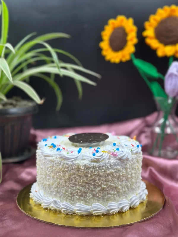 Whole White Forest cake decorated with white chocolate curls and sprinkles