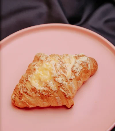 Cheese croissant with cheese oozing from golden crust
