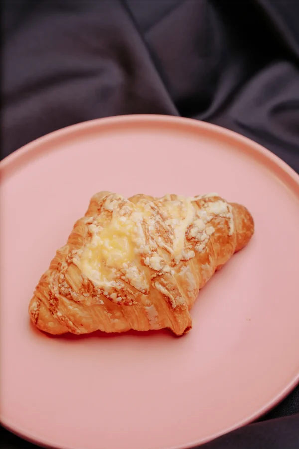 Cheese croissant with cheese oozing from golden crust