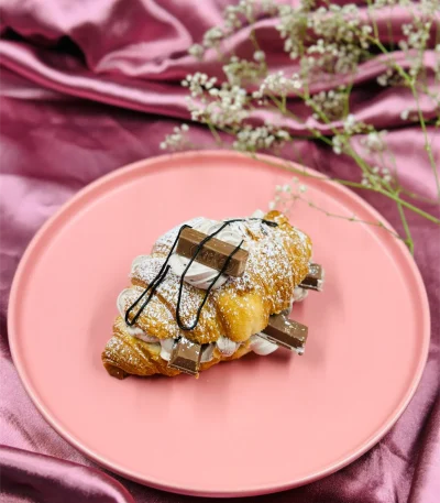 Kitkat Croissant plated with extra cream, molten chocolate and kitkat chunks