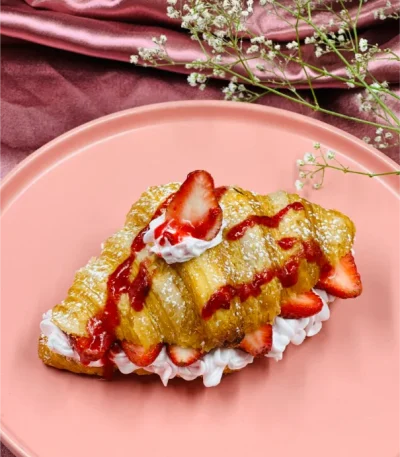 Fresh Strawberry Croissant topped with cream and strawberry