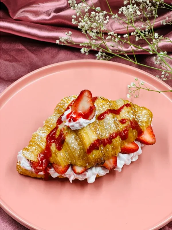 Fresh Strawberry Croissant topped with cream and strawberry
